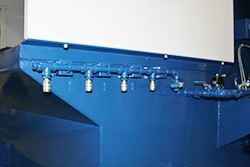 Close-up of compressed air manifold on a Uni-Wash dust collector, showing multiple air nozzles for efficient dust removal in industrial applications.