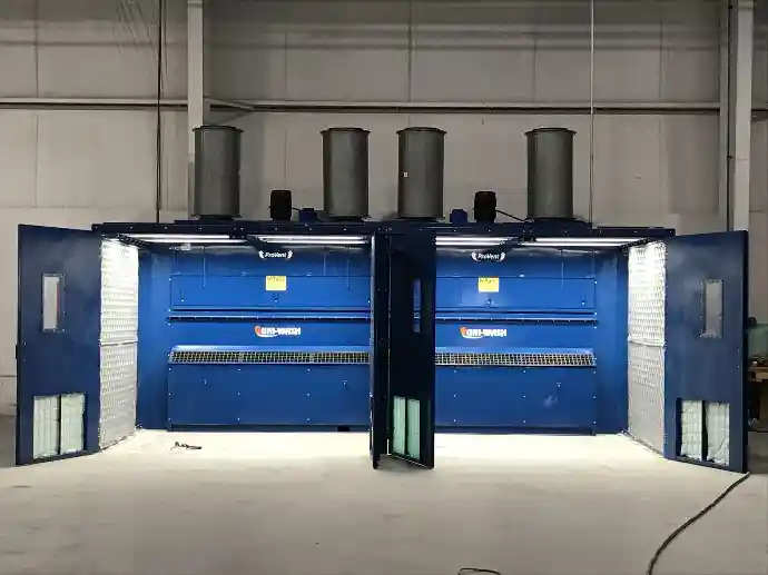 Dual-station ProVent UNI-WASH industrial dust collection booth with two large open work areas, overhead ducting, and integrated filtration systems inside a spacious industrial facility.